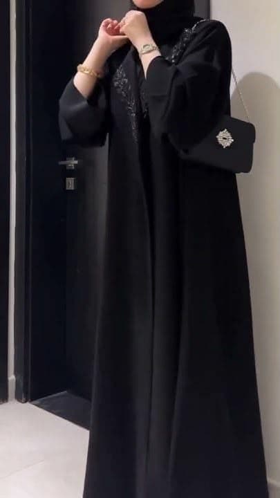 Black beaded evening abaya with crystal clutch and gold bracelet